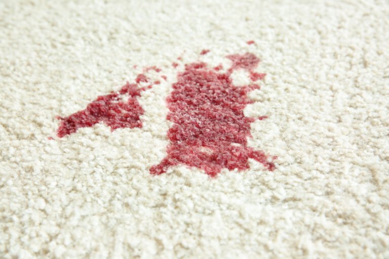 Tapis blanc taché de vin rouge avant détachage